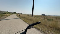 the view from the handlebar of a bicycle on a grassy path