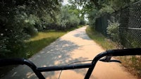 a bike rider's view of a path through a wooded area